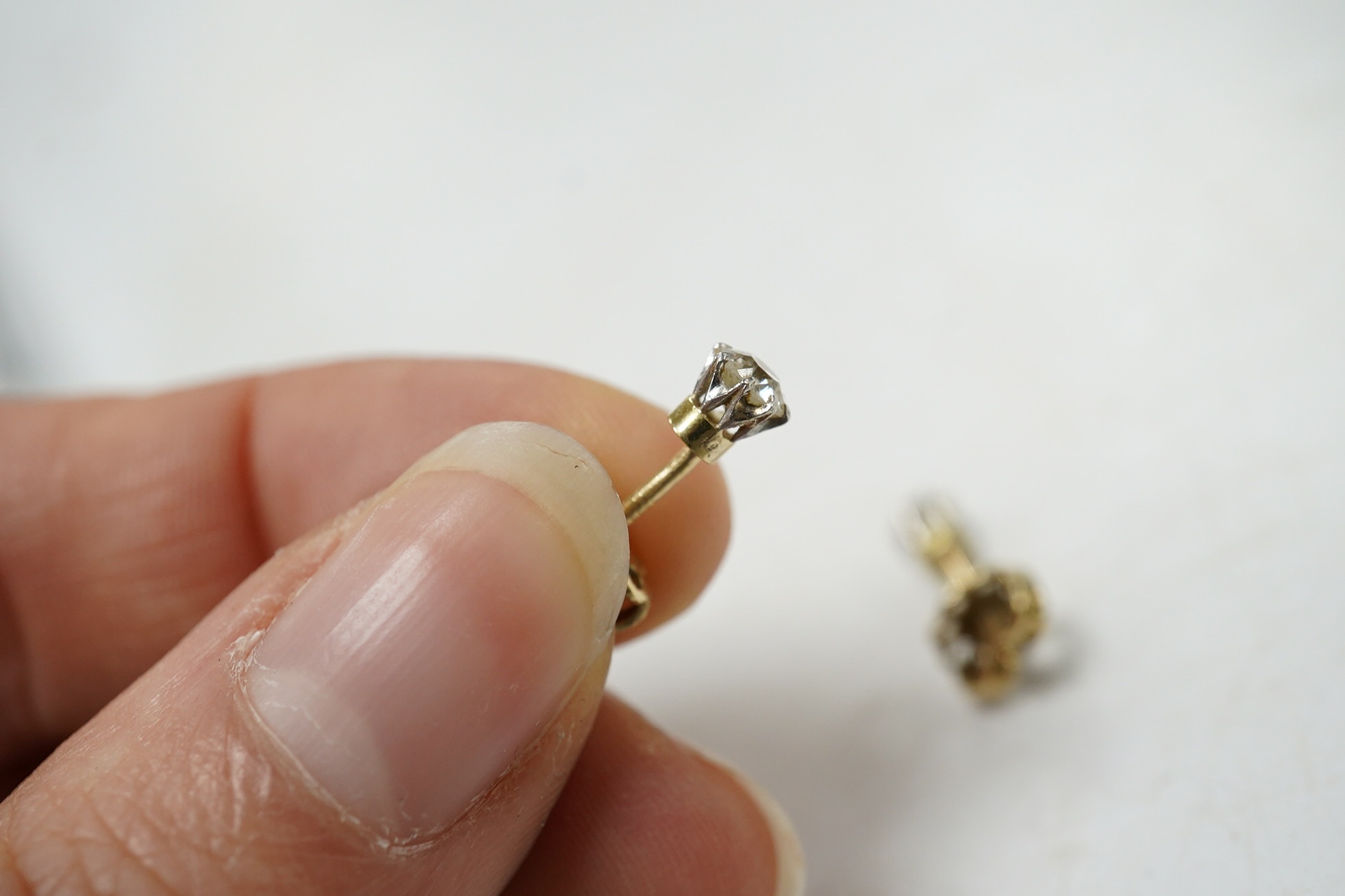 A pair of yellow metal and solitaire diamond set ear studs, gross weight 1 gram. Condition - fair to good